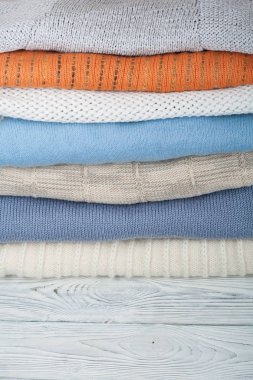 Örgü yün kazaklar. Ahşap arka planda örülmüş kış kıyafetleri, kazaklar, örgü giysileri, metin için yer.