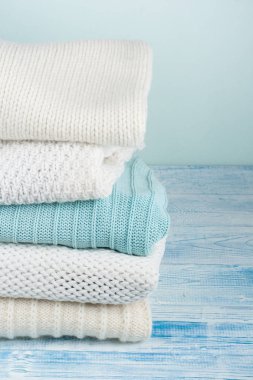 Örgü yün kazaklar. Ahşap arka planda örülmüş kış kıyafetleri, kazaklar, örgü giysileri, metin için yer.