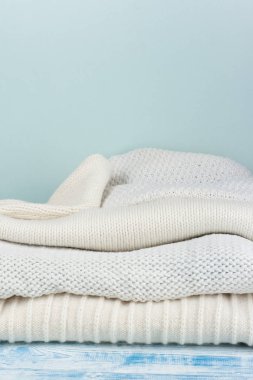 Örgü yün kazaklar. Ahşap arka planda örülmüş kış kıyafetleri, kazaklar, örgü giysileri, metin için yer.