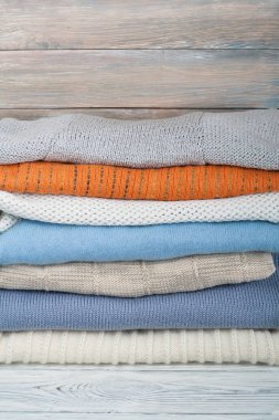 Örgü yün kazaklar. Ahşap arka planda örülmüş kış kıyafetleri, kazaklar, örgü giysileri, metin için yer.