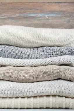 Örgü yün kazaklar. Ahşap arka planda örülmüş kış kıyafetleri, kazaklar, örgü giysileri, metin için yer.