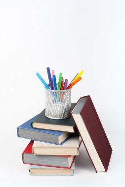 Açık kitap, ahşap masa, beyaz arka plan üzerinde renkli ciltli kitap. Okula dönüş. Kalem, kalem, bardak. Metin için yer kopyalayın. Eğitim iş kavramı