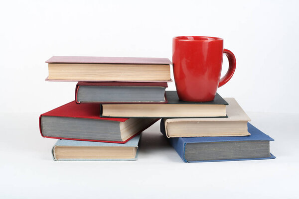 Open book, hardback colorful books on wooden table, white background. Back to school. Cup. Copy space for text. Education business concept