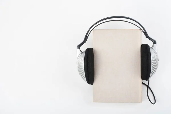 白色背景上的有声读物 耳机放书 空封面 复制广告文字空间 远程教育 电子学习理念 — 图库照片