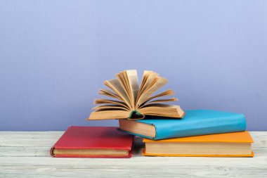 Açık kitap, ahşap masa üzerinde renkli ciltli kitap. Okula dönüş. Metin için yer kopyalayın