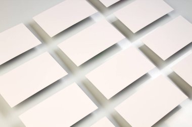 Beyaz desenli kağıt arka planda sıralanmış yatay kartvizit destelerinin bir kopyası