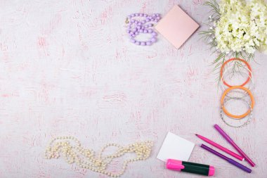 Bilgisayarlı çalışma alanı, buket ortancalar, pano. Pembe arka planda izole edilmiş kadın aksesuarları. Düz yatıyordu. Üst görünüm ofis masası