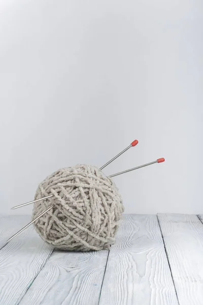 Ball of wool with spokes for handmade knitting on wooden table. Knitting wool and knitting needles