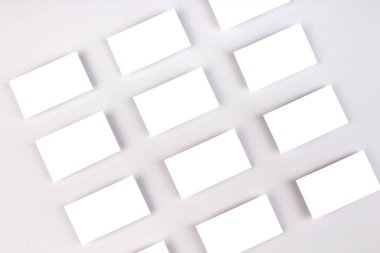 Beyaz desenli kağıt arka planda sıralanmış yatay kartvizit destelerinin bir kopyası