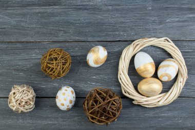 Mutlu Paskalyalar. Tahta arka planda yumurtalar... Toplar, sarmaşıklardan örülmüş çelenkler. Uzayı metin için kopyala. Üst görünüm