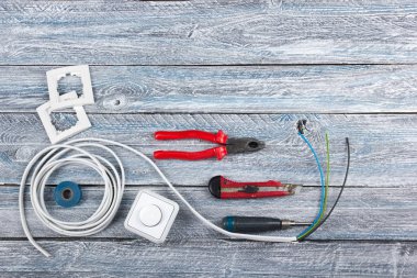 Elektrikçi, ahşap arka planda dekorasyon ve yenileme için profesyonel onarım araçları. Elektrikli aletler. Üst görünüm. Metin için alanı kopyala.