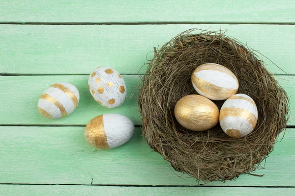 Frohe Ostern. Nest von oben mit bemalten Eiern auf Holztisch. Kopierraum für Text. — Stockfoto