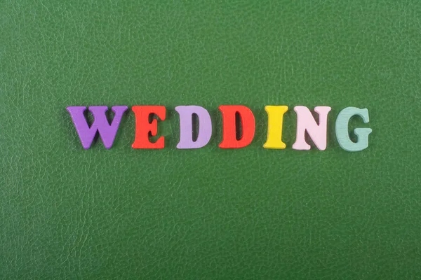 Renkli abc alfabe blok ahşap harflerden oluşan yeşil arka plan üzerinde Düğün kelime, reklam metni için kopya alanı. İngilizce kavramını öğrenme.