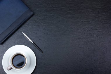 Siyah ofis masa masası bilgisayar, kalem ve bir fincan kahve, bir sürü şey. Kopya alanı ile üst görünüm.