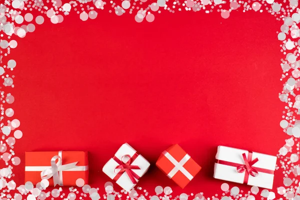 Dárkové krabice a barevný dárek k Vánocům na červeném pozadí. Pohled shora s prostorem kopírování. — Stock fotografie