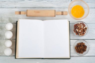 Tarifi ahşap arka plan, kaşık, oklava, damalı masa örtüsü üzerinde yemek boş kitap