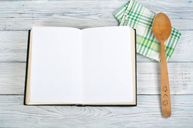 Tarifi ahşap arka plan, kaşık, oklava, damalı masa örtüsü üzerinde yemek boş kitap