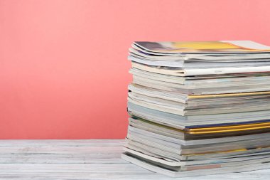 Açık istifleme kitap, ahşap masa ve kırmızı, pembe arka plan üzerinde dergi ciltli renkli kitaplar. Okula geri dön. Metin için alan kopyalayın. Eğitim iş kavramı.