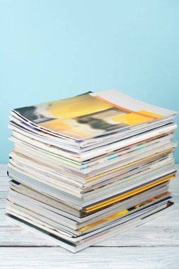 Açık istifleme kitap, ahşap masa ve mavi arka plan üzerinde dergi hardback renkli kitaplar. Okula geri dön. Metin için alan kopyalayın. Eğitim iş kavramı.