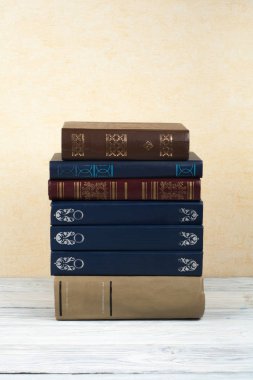 Açık istifleme kitabı, ahşap masa ve sarı arka plan üzerinde ciltli renkli kitaplar. Okula geri dön. Metin için alan kopyalayın. Eğitim iş kavramı.