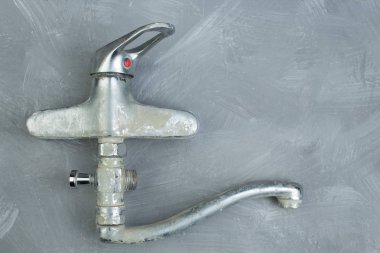 Gri beton duvarda musluk var. Uzayı kopyala Üst görünüm.