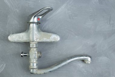 water-tap on the gray concrete wall . Copy space. Top view. clipart