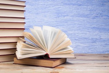 Açık bir kitap, mavi arka planda kitaplar. Okula dönelim. Eğitim. Metin için alanı kopyala.