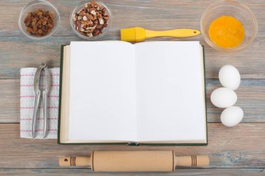 Tarifi ahşap arka plan, kaşık, oklava, damalı masa örtüsü üzerinde yemek boş kitap