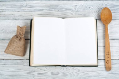 Tarifi ahşap arka plan, kaşık, oklava, damalı masa örtüsü üzerinde yemek boş kitap