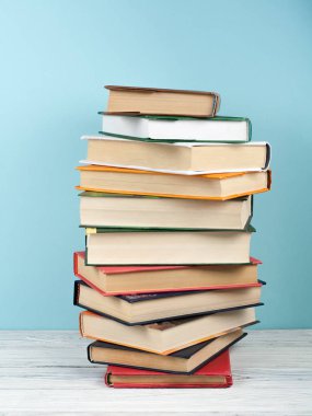 Açık istifleme kitap, ahşap masa ve mavi arka plan üzerinde ciltli renkli kitaplar. Okula geri dön. Metin için alan kopyalayın. Eğitim iş kavramı.