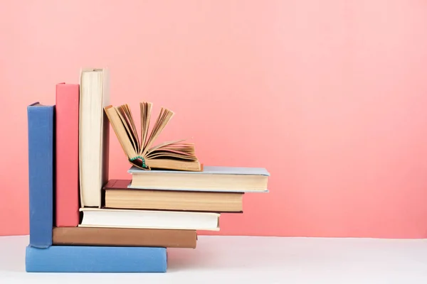 Libro abierto, libros de colores sobre mesa de madera, fondo rojo, rosa. De vuelta a la escuela. Copia espacio para texto. Concepto de negocio educativo . —  Fotos de Stock