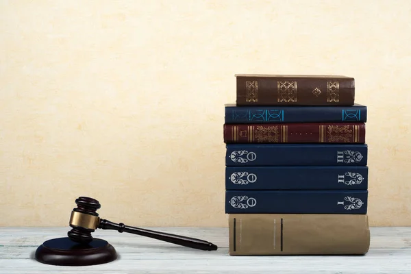 法律概念开放书籍与木制法官在法庭或执法办公室的桌子上，黄色米色背景。文本的复制空间. — 图库照片