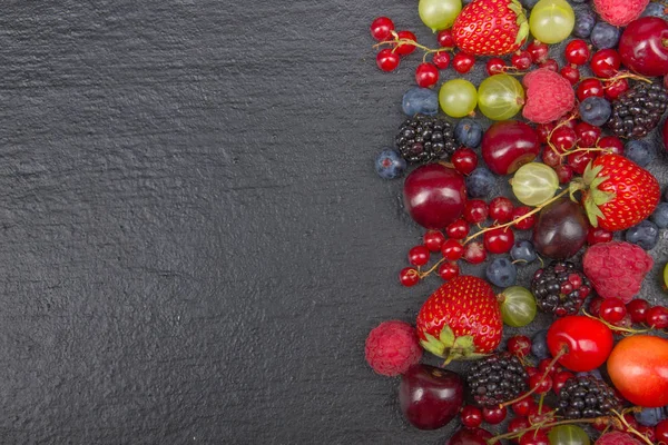 Varias bayas frescas de verano en un tazón sobre una mesa de madera rústica. Antioxidantes, dieta de desintoxicación, frutas orgánicas. Vista superior — Foto de Stock