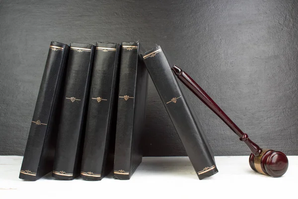 Concepto de ley: libro de leyes abierto con un mazo de jueces de madera sobre la mesa en una sala de tribunal o en una oficina de aplicación de la ley aislada en una mesa blanca. Copiar espacio para texto . — Foto de Stock