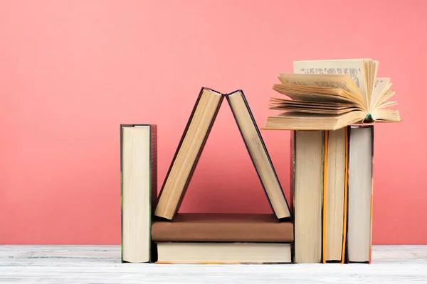 Nyílt könyv, keménykötésű színes könyvek fából készült asztal, piros, rózsaszín ba — Stock Fotó