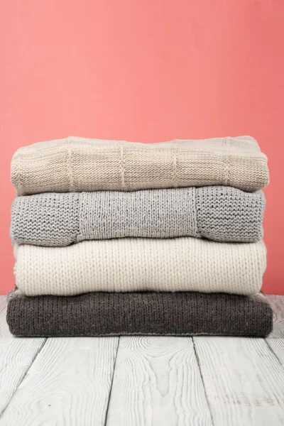 Örme yün kazaklar. Örme kış yığını, kırmızı sonbahar giysileri, ahşap arka plan, kazak, triko, metin için alan.