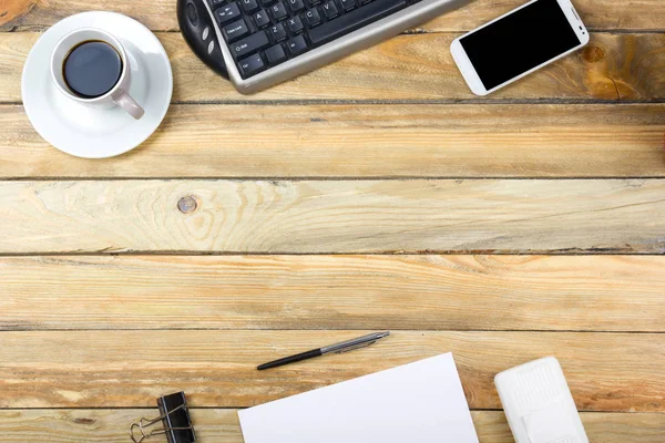 Schreibtisch im Büro mit Computer, Stift und einer Tasse Kaffee, viele Dinge. Draufsicht mit Kopierraum. — Stockfoto