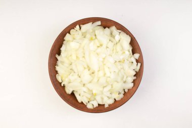 White onion cubes in wooden bowl isolated on white background. Top view.