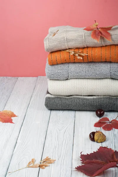 Camisolas de lã de malha. Pilha de inverno de malha, roupas de outono em vermelho, fundo de madeira, camisolas, malhas, espaço de folha para texto . — Fotografia de Stock