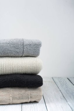 Örgü yün kazaklar. Ahşap arka planda örülmüş kış kıyafetleri, kazaklar, örgü giysileri, metin için yer..