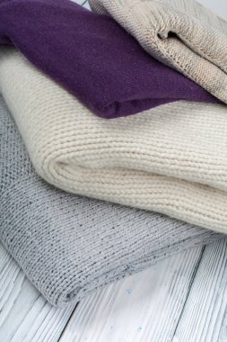 Örgü yün kazaklar. Ahşap arka planda örülmüş kış kıyafetleri, kazaklar, örgü giysileri, metin için yer..