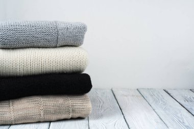 Örgü yün kazaklar. Ahşap arka planda örülmüş kış kıyafetleri, kazaklar, örgü giysileri, metin için yer..