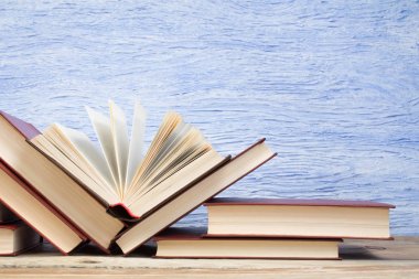 Açık bir kitap, mavi arka planda kitaplar. Okula dönelim. Eğitim. Metin için alanı kopyala.