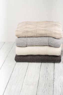 Örgü yün kazaklar. Ahşap arka planda örülmüş kış kıyafetleri, kazaklar, örgü giysileri, metin için yer..