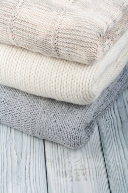 Örgü yün kazaklar. Ahşap arka planda örülmüş kış kıyafetleri, kazaklar, örgü giysileri, metin için yer..