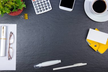Siyah ofis masa masası bilgisayar, kalem ve bir fincan kahve, bir sürü şey. Kopya alanı ile üst görünüm.