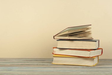 Kitap istifleme. Ahşap masa ve bej arka plan açık ciltli kitap. Okula dönüş. Kopya alanı reklam metni için.