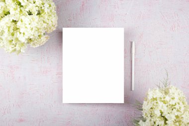 Bilgisayarlı çalışma alanı, buket ortancalar, pano. Pembe arka planda izole edilmiş kadın aksesuarları. Düz yatıyordu. Üst görünüm ofis masası.