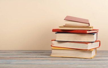 Kitap istifleme. Ahşap masa ve bej arka plan açık ciltli kitap. Okula dönüş. Kopya alanı reklam metni için