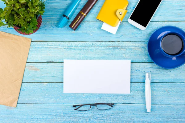 Mesa de escritório azul com computador, caneta e uma xícara de café, muitas coisas. Vista superior com espaço de cópia. — Fotografia de Stock